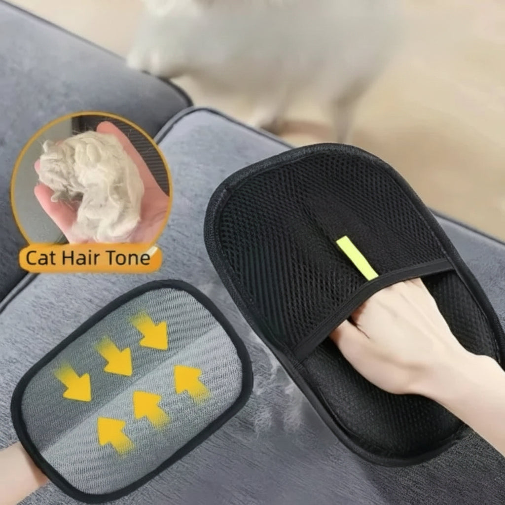 Black pet deshedding glove with mesh palm and yellow strap, held in a hand.